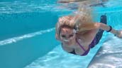 brunette girl in tight blue jeans swimming and diving in water